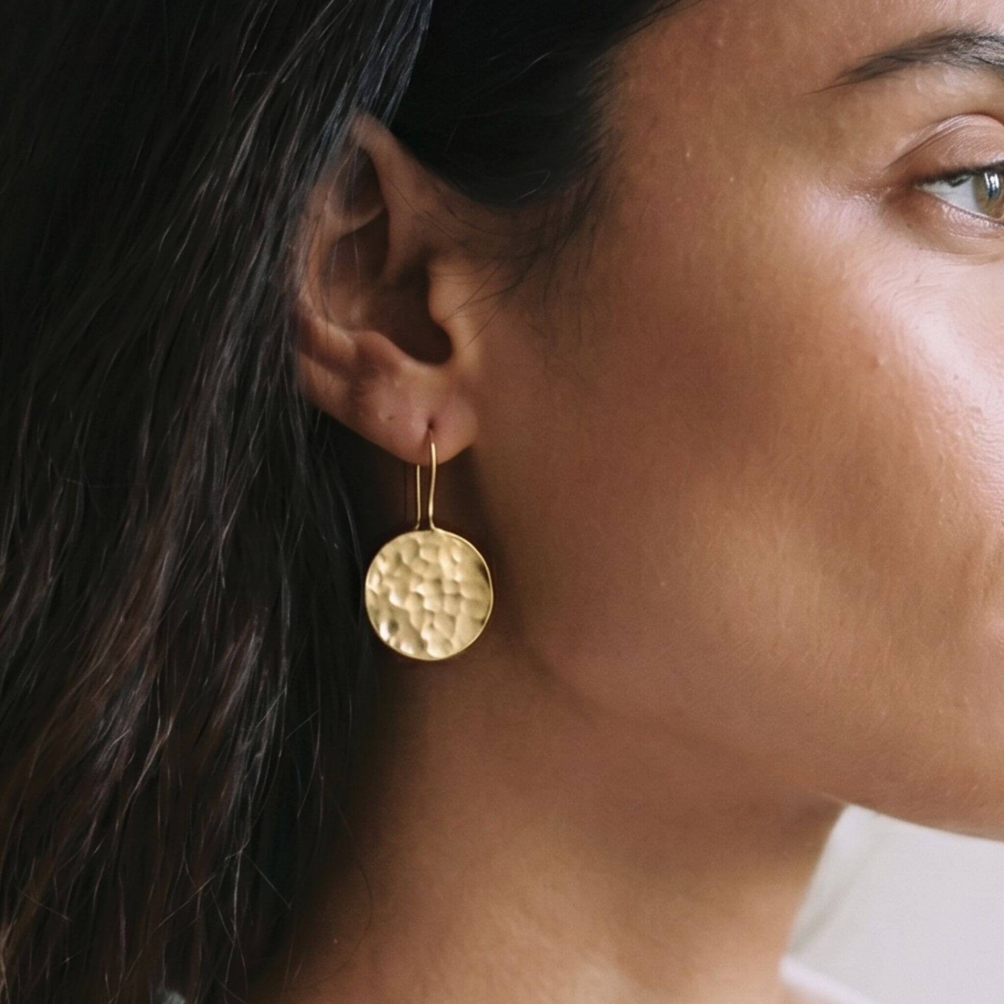 Njiwa hammered disc brass drop earrings flat lay — Ecodunia