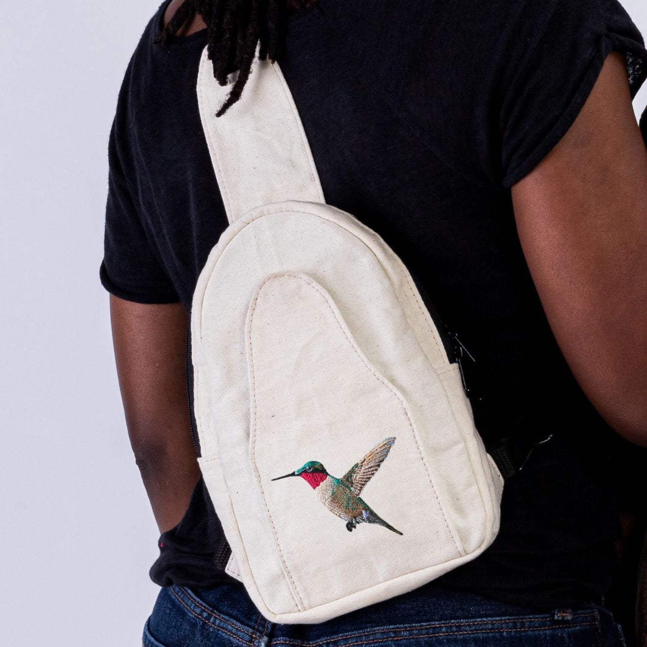Buru hummingbird embroidery detail on canvas sling bag front panel