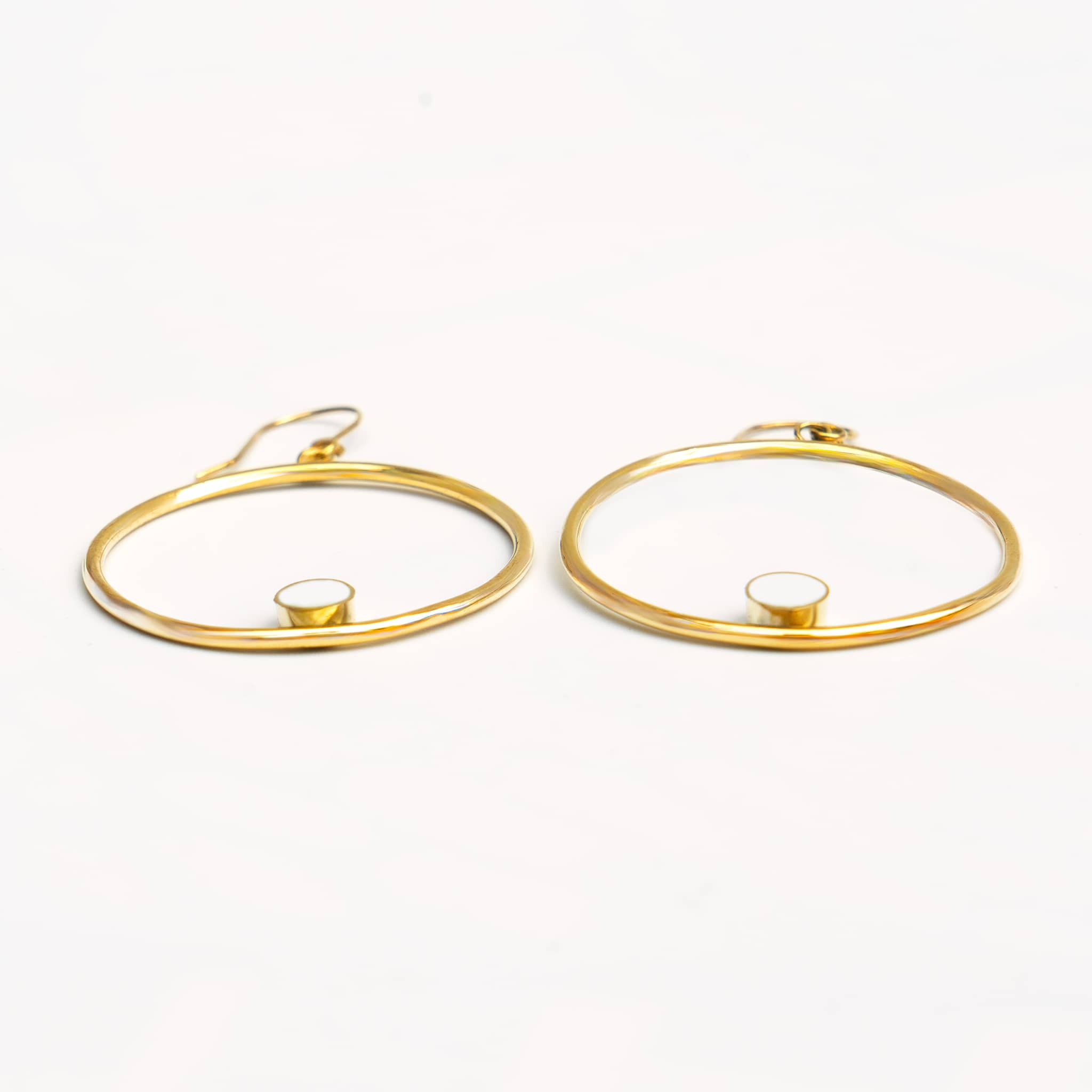 Lozi brass hoop with white horn accent earrings flat lay — Ecodunia