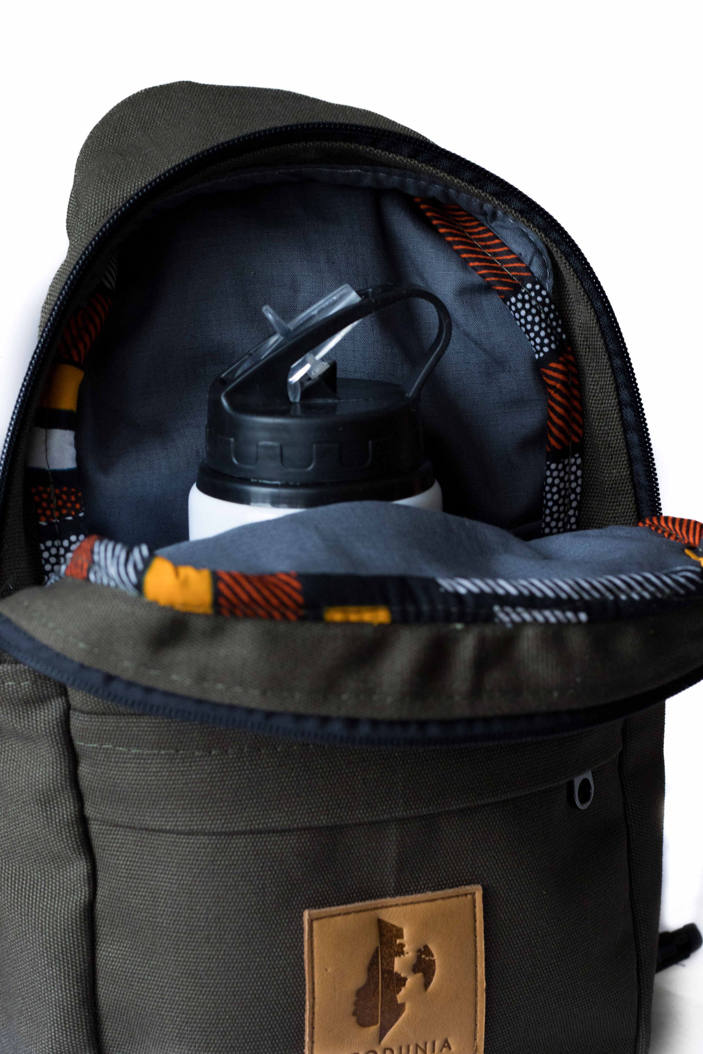 Umoja green canvas sling bag worn hiking