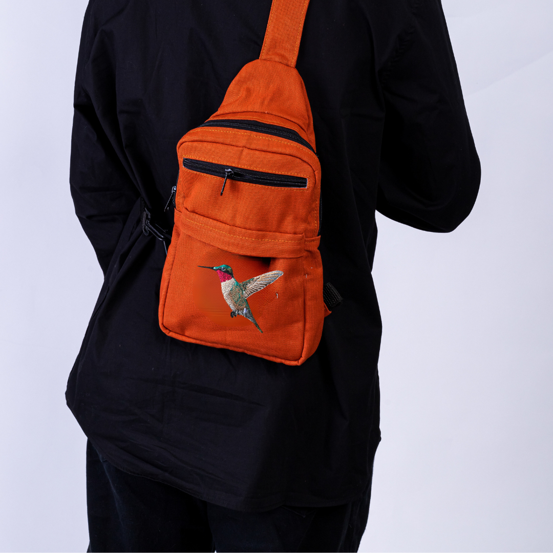 Umoja hummingbird embroidered canvas sling bag in rust