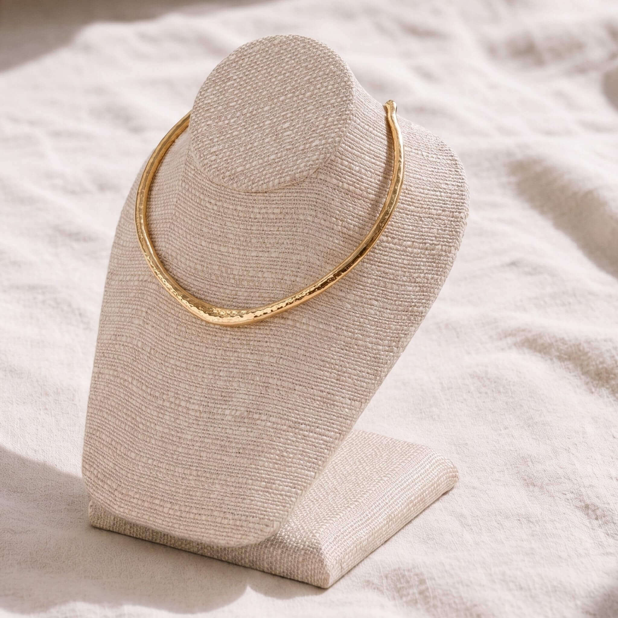 Sana hammered brass cuff choker necklace flat lay on warm surface — Ecodunia