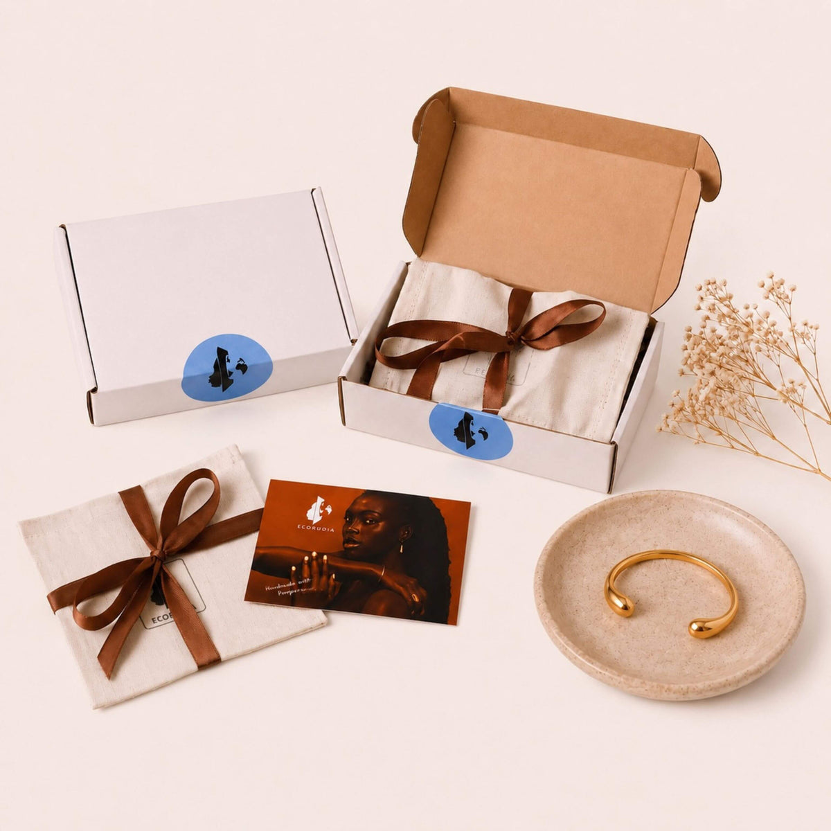 A styled flat-lay of a jewelry gift set on a warm cream background.