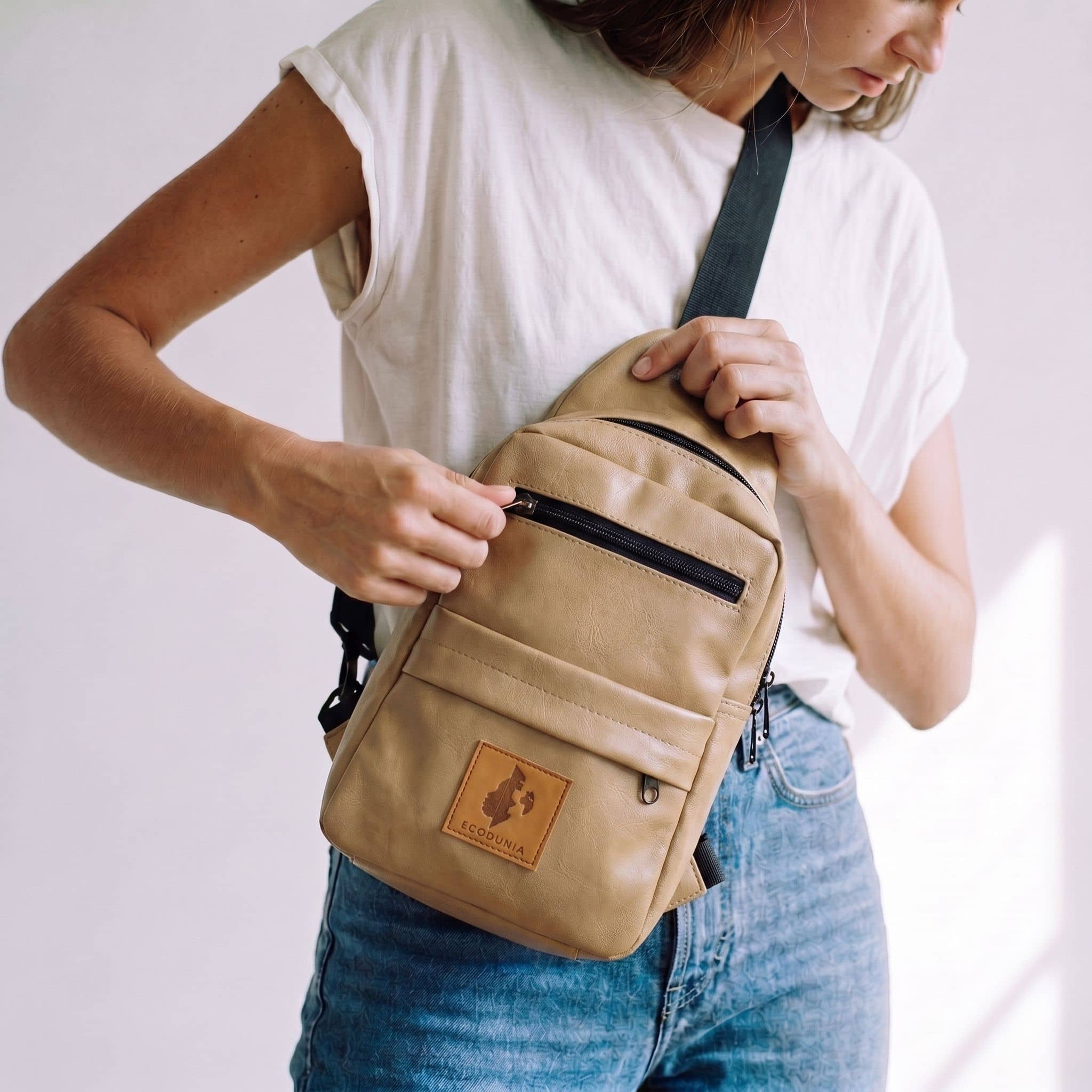 Umoja latte vegan leather sling bag flat lay 