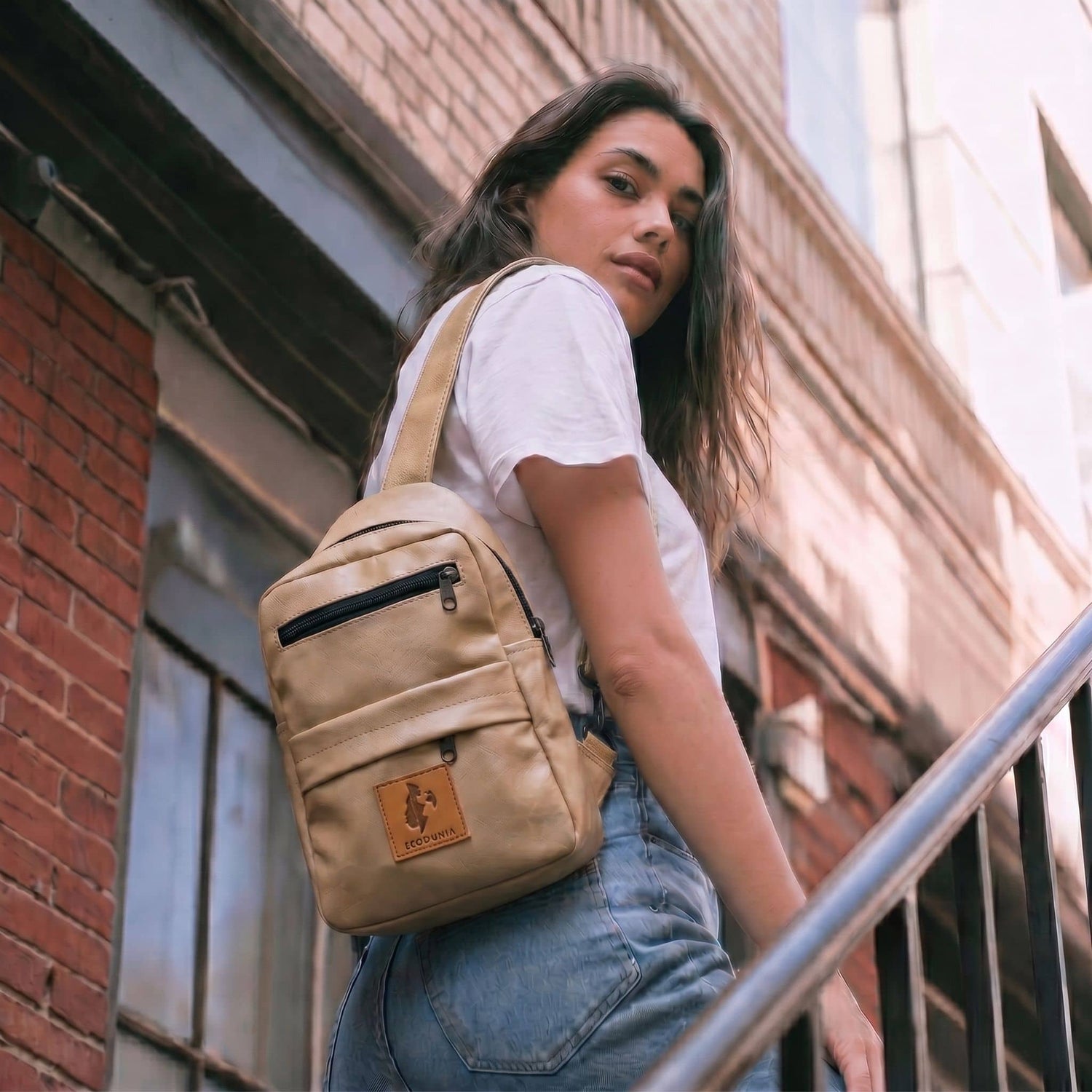 Umoja latte vegan leather sling bag flat lay 