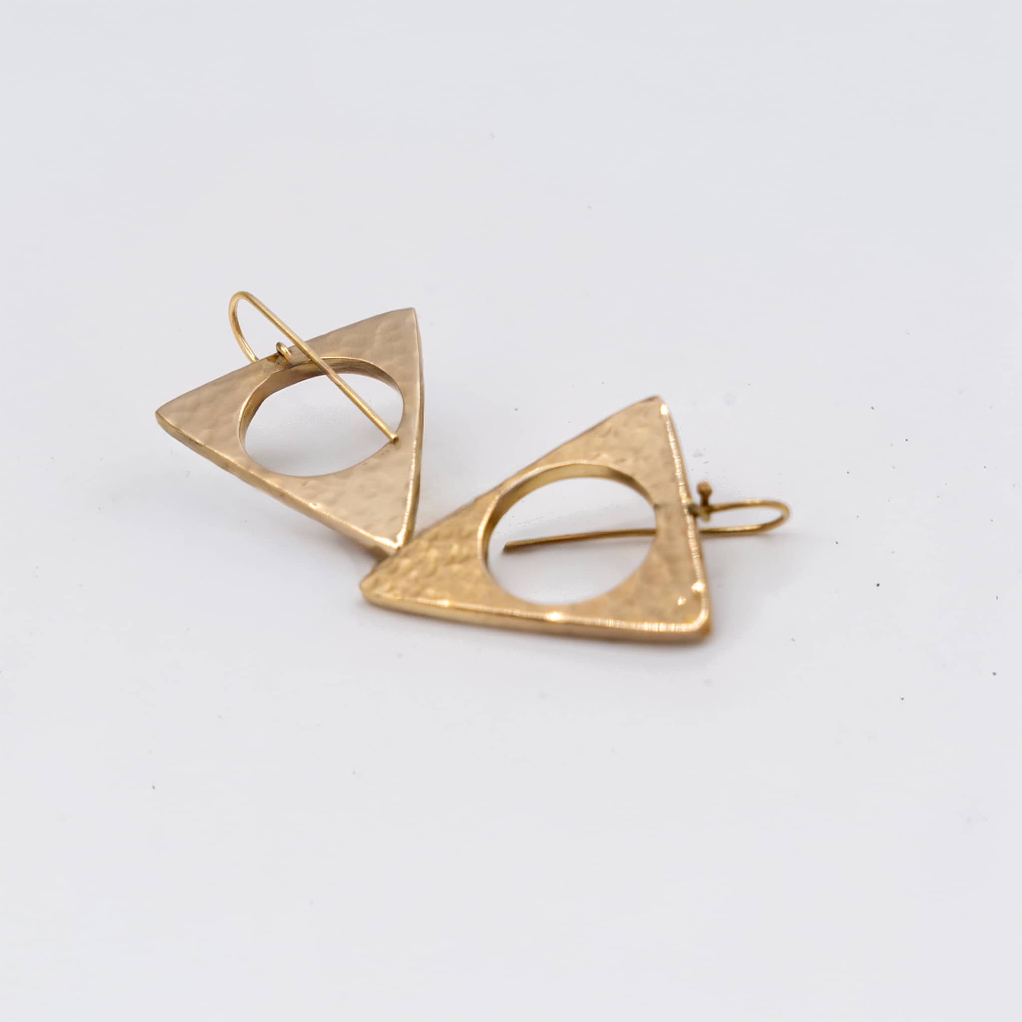 Lia hammered triangle brass earrings worn showing geometric form