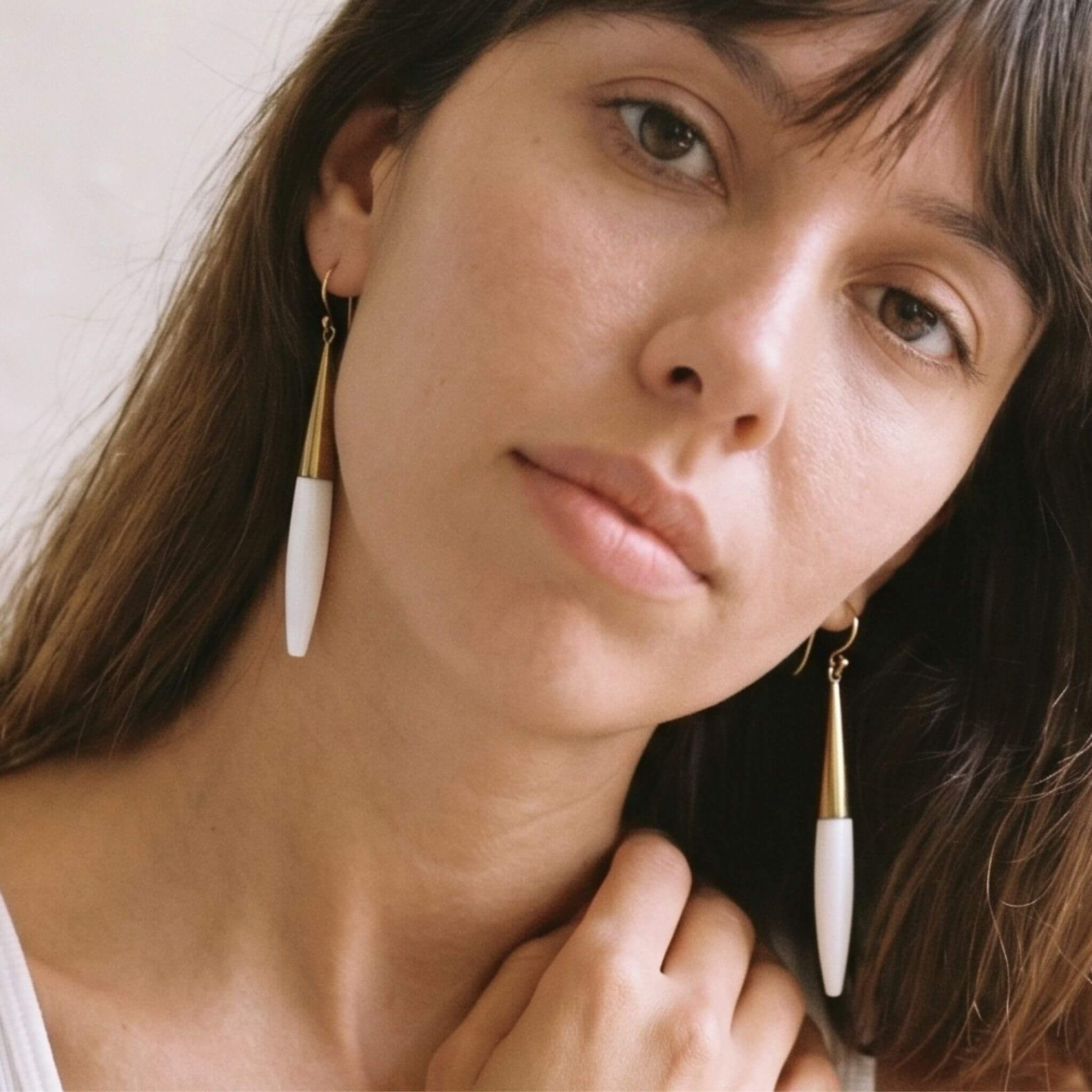 Luna brass and white horn spike drop earrings flat lay — Ecodunia 