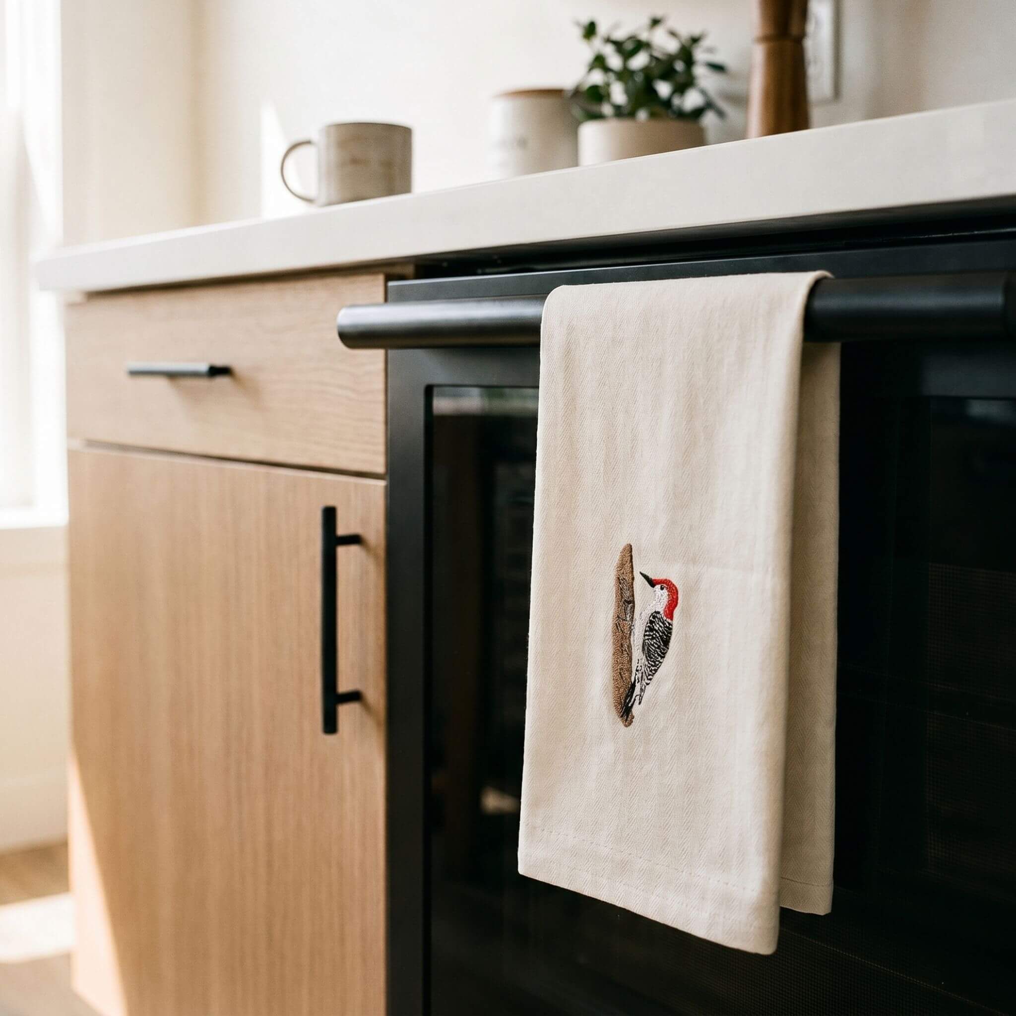 Woodpecker bird embroidered cotton tea towel flat lay on white surface 